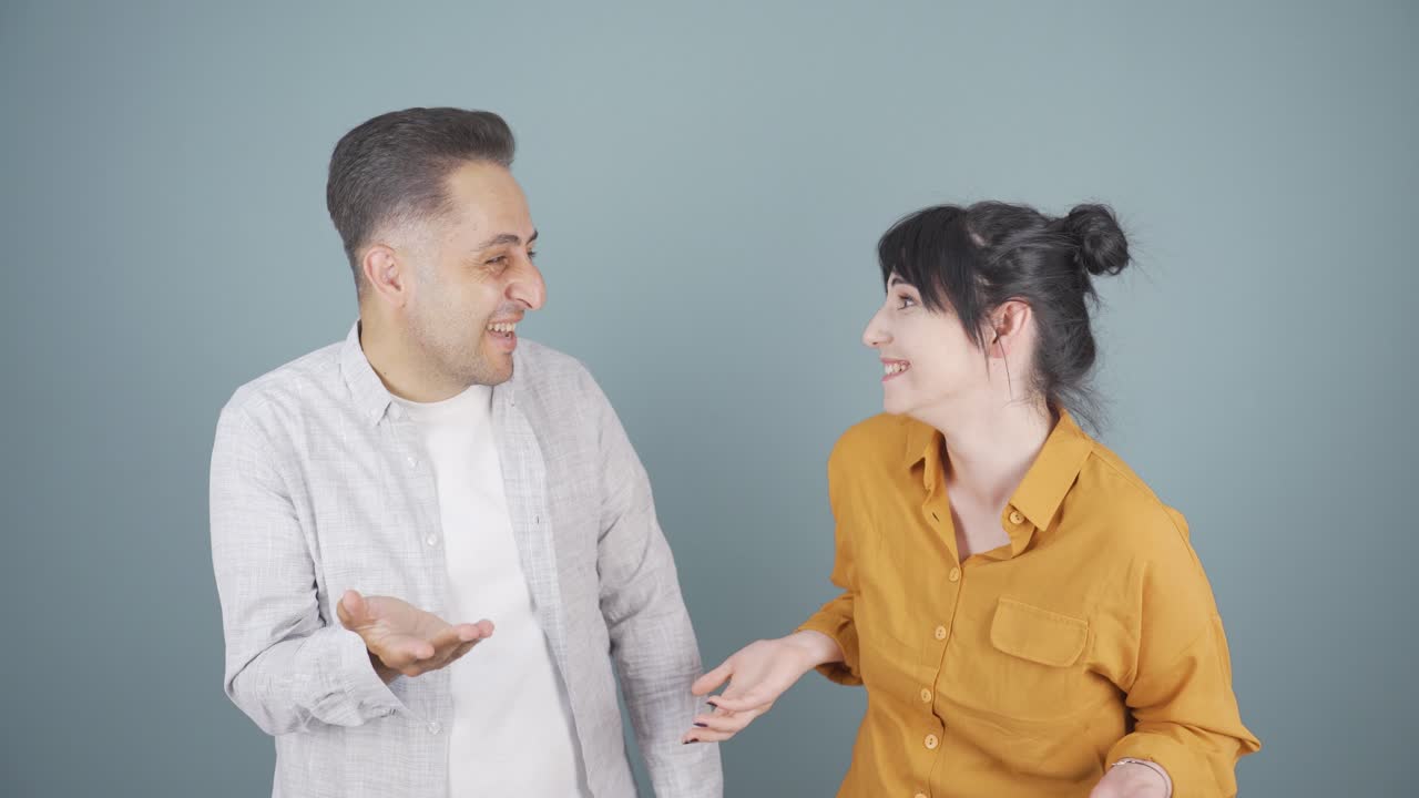 pareja casada mirándose el uno al otro con asombro.