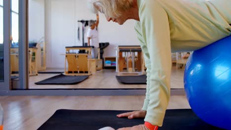 Senior-woman-exercising-on-exercise-ball-4k