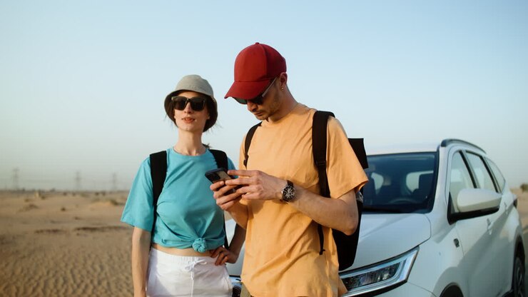 Coppia che usa lo smartphone nel deserto