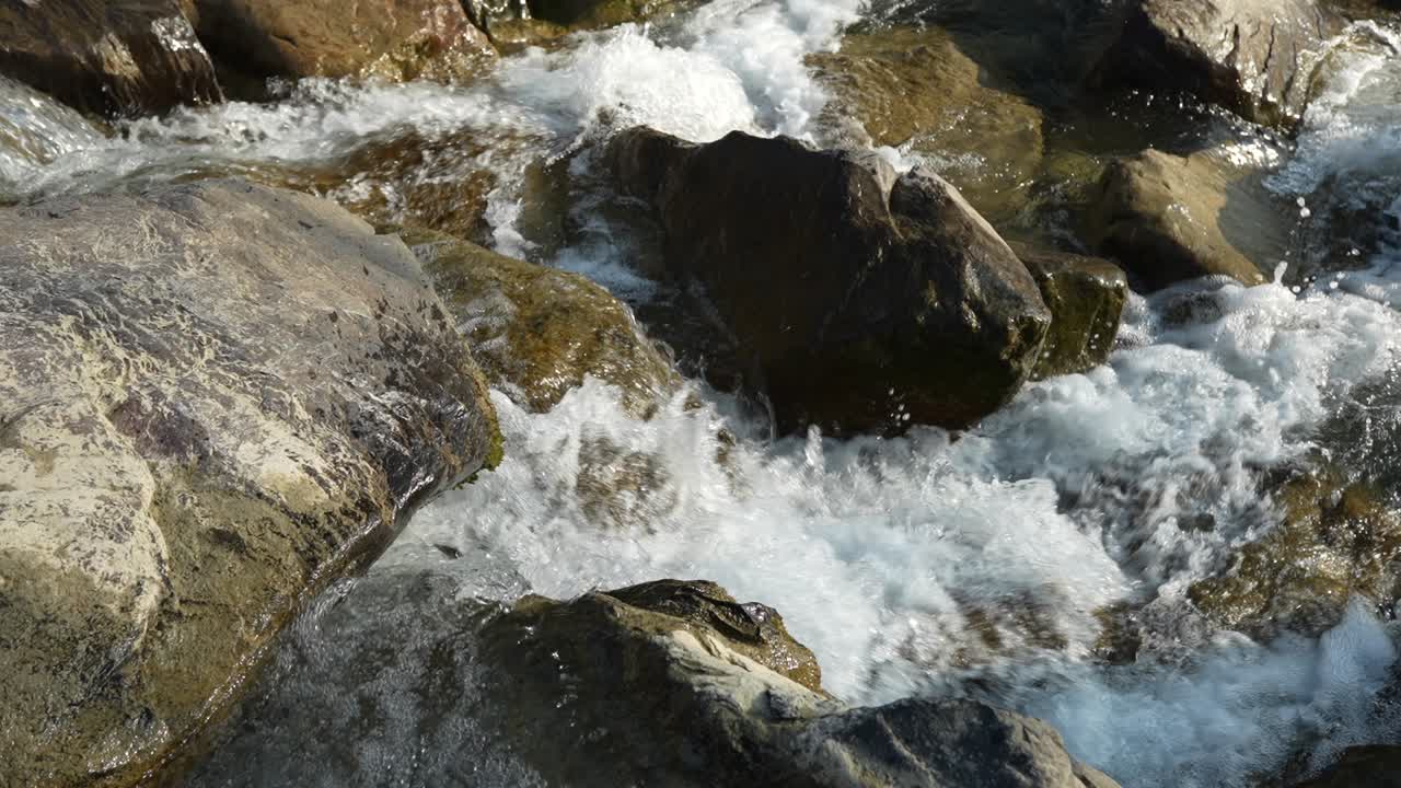 Vista al rallentatore di una piccola cascata con acque cristalline.