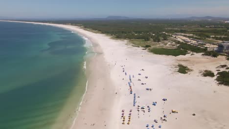 large and extensive beach with few people enjoying a sunny day wonderful view of linda da natura and the waves of the sea in its natural beauty