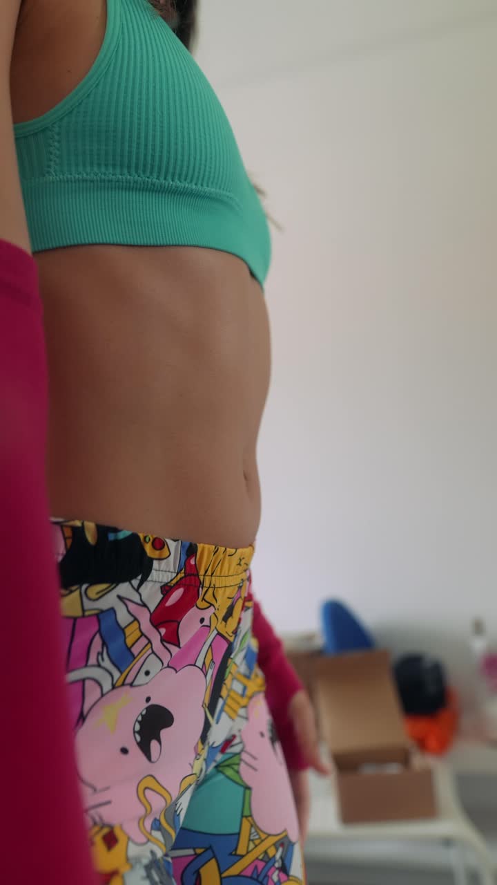 Young Woman Flexing Abdominal Muscles in Sports Bra