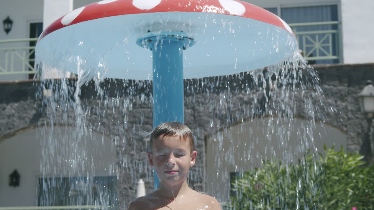 un niño tomando una ducha al aire libre