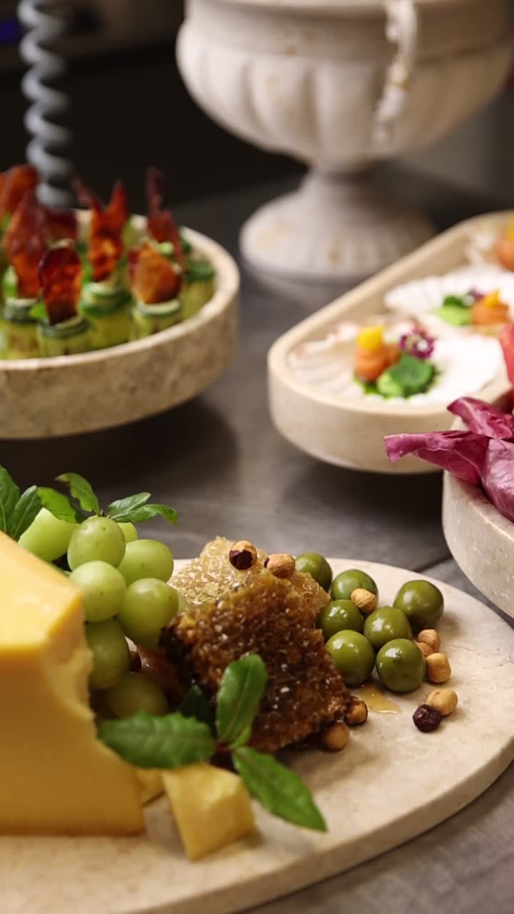 Antipasti gourmet e tagliere di formaggi con uva, favo di miele e olive