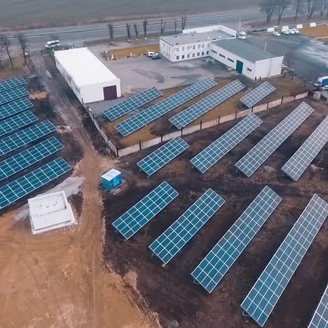 solar batteries on the ground near factory or plant. addicional sourse of green energy. video from the top