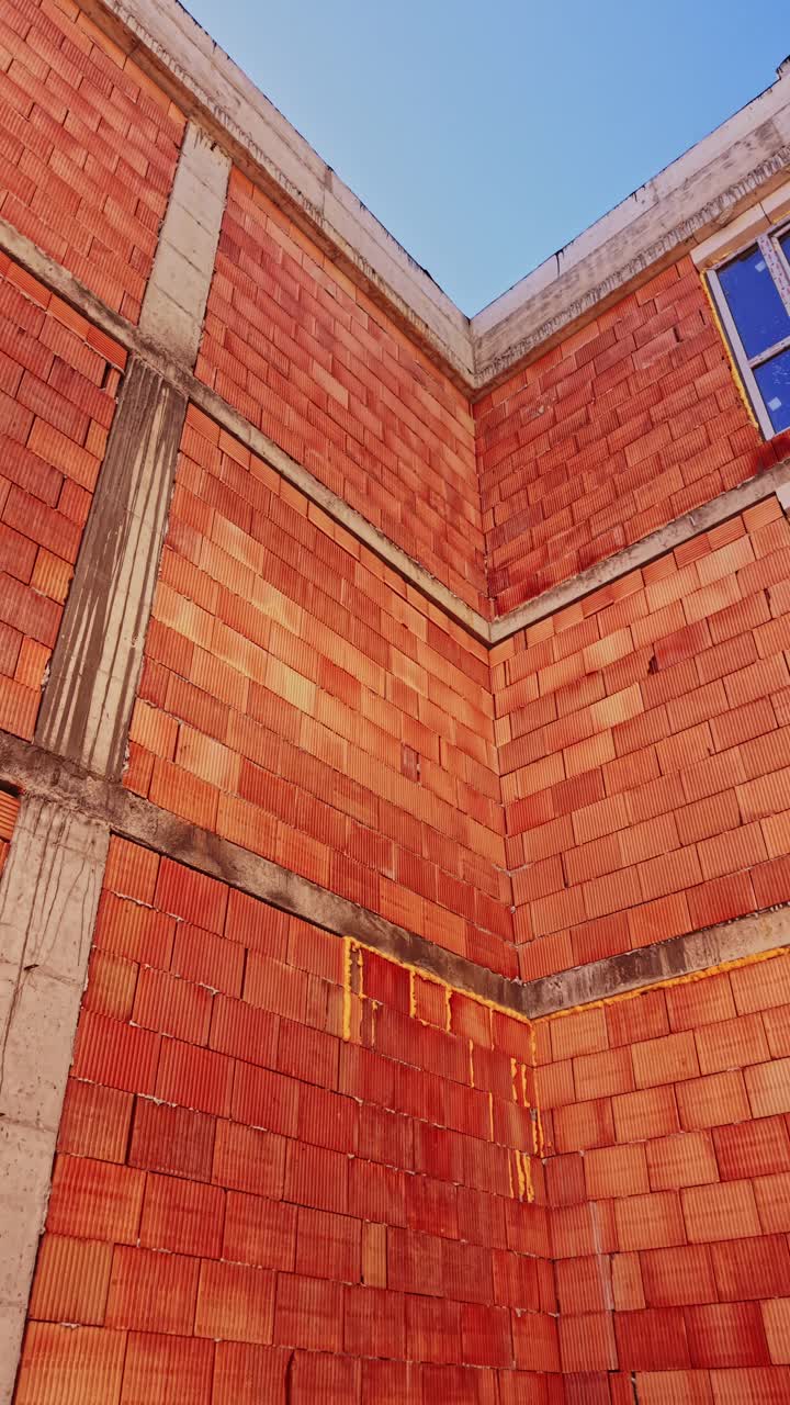 Low angle view of brick building corner and blue sky