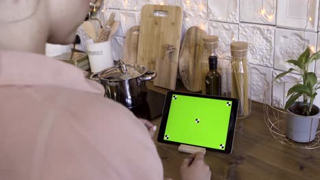 mujer usando una tableta en una cocina