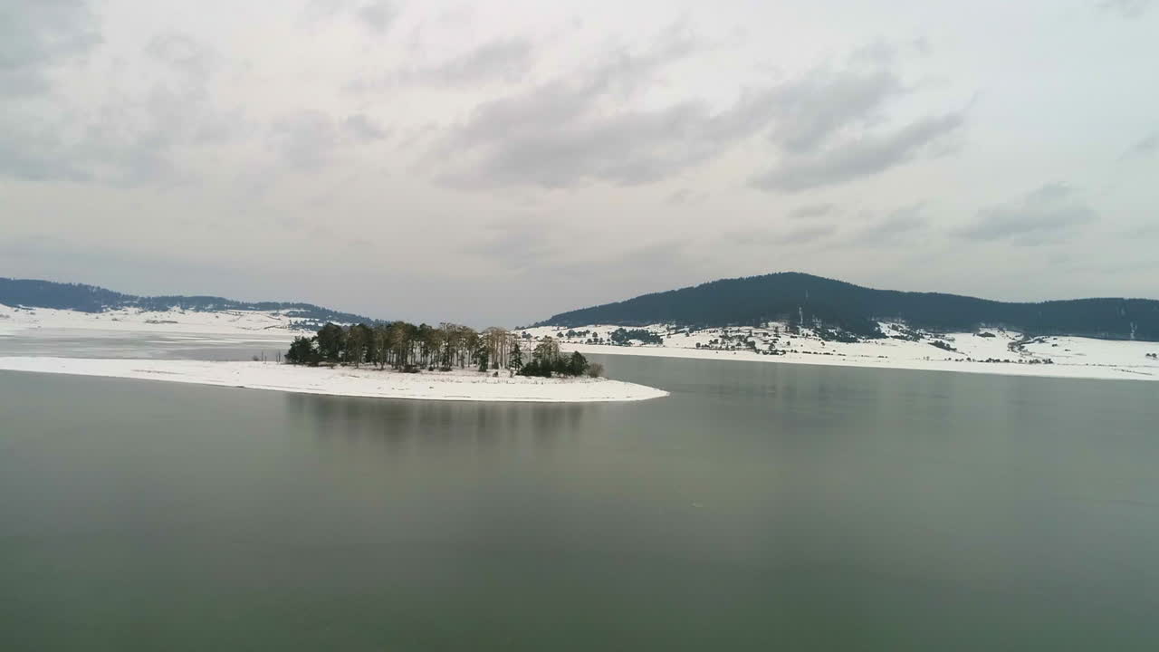 공중: 나무가 있는 섬이 있는 호수 위를 나는 것