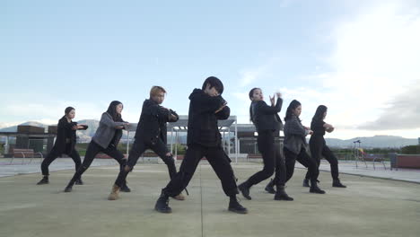 young street performer performing on the street. seven chinese teenagers dancing kpop