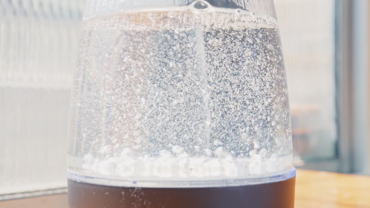 透明な水のボトルでの煮沸消毒。安全で健康的な飲用のための水消毒プロセス。
