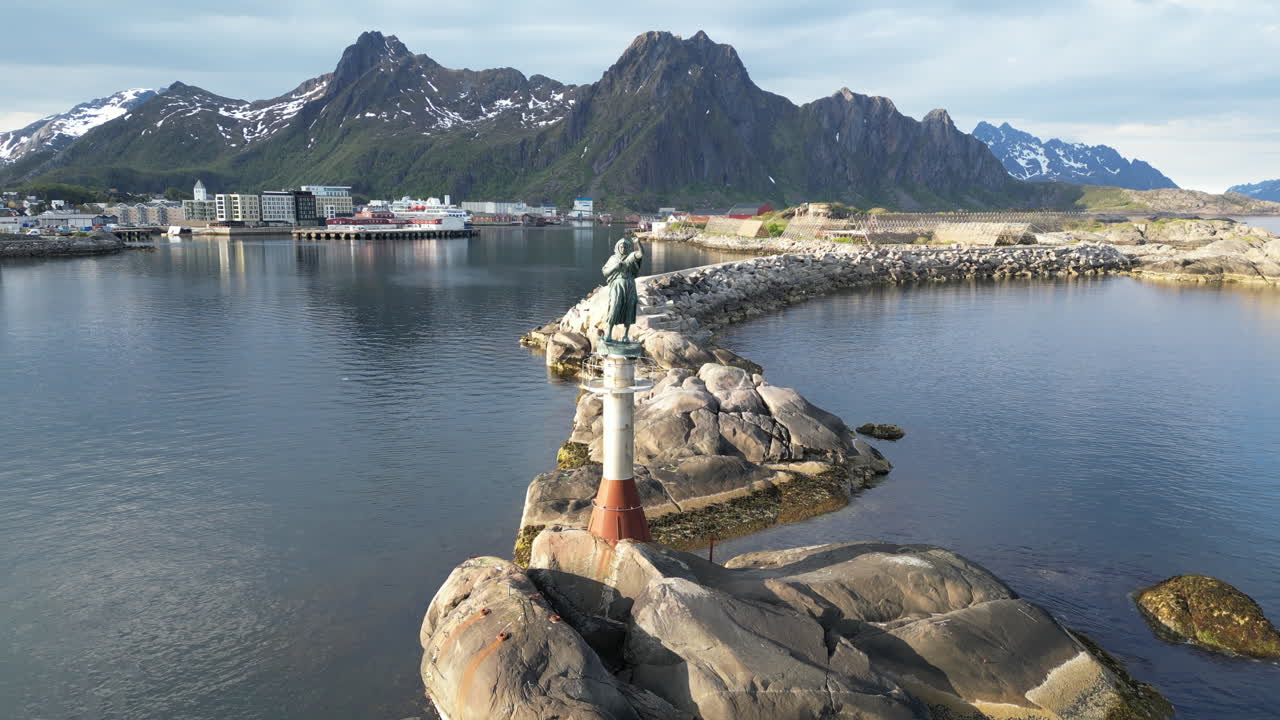 puesta de sol dorada sobre la estatua de la esposa del pescador en svolvaer, islas lofoten