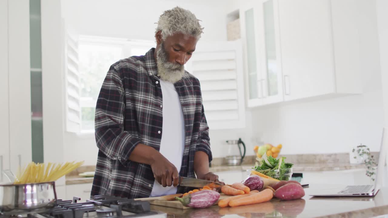 Senior man chopping vegetables in the kitchen