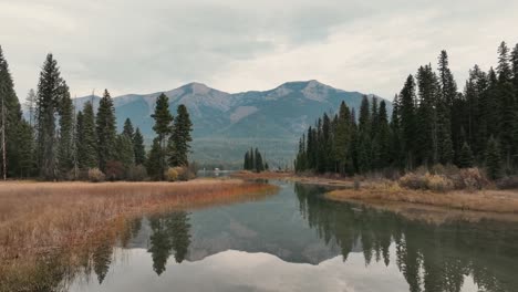 mirror reflections in tranquil river with ridges in the background