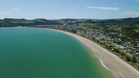 Perfecto-Día-De-Verano-A-Lo-Largo-De-Cooks-Beach-En-Nueva-Zelanda-Con-Montañas-Verdes-En-El-Fondo-Después-De-Que-El-Ciclón-Gabrielle-Arrasara-Una-Semana-Antes