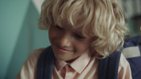 Happy-boy-having-fun-on-school-break-close-up.-Smiling-kid-looking-down-playing.