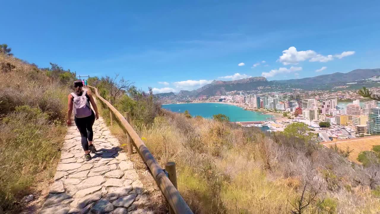 Young Female Hiker Reaching the Summit of Penon de Ifach with Coastal Views