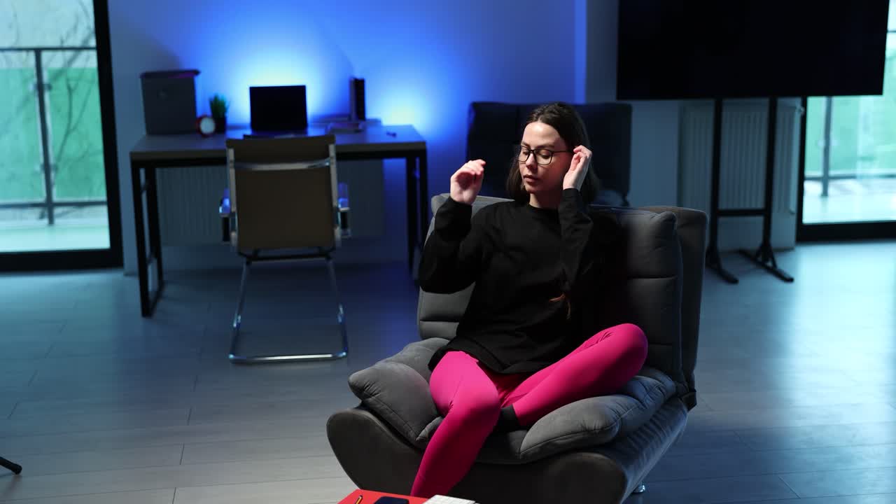 한 여자가 방 의자에 앉아 있다