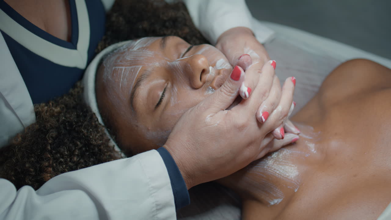 esthéticienne en gros plan massant le visage après la procédure de beauté. mains femme relaxante