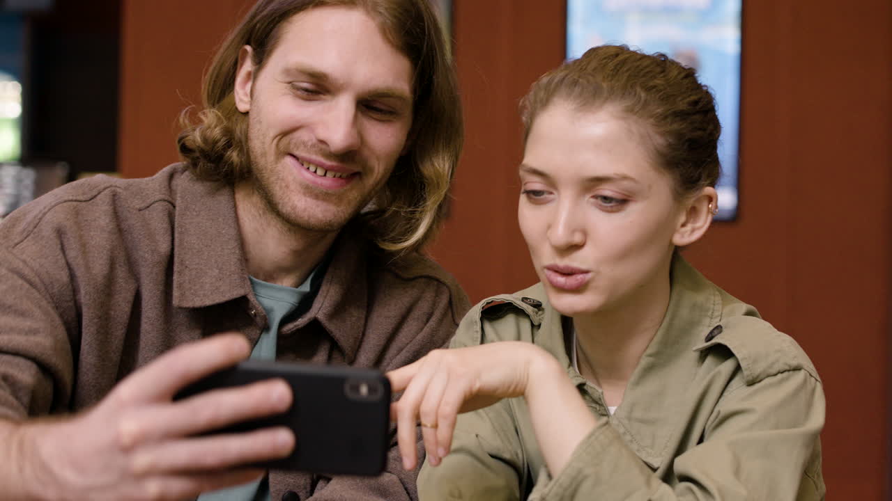 retrato de una pareja feliz tomando un selfie con teléfono en el cine