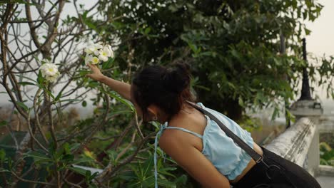 woman with plumeria flower outdoors