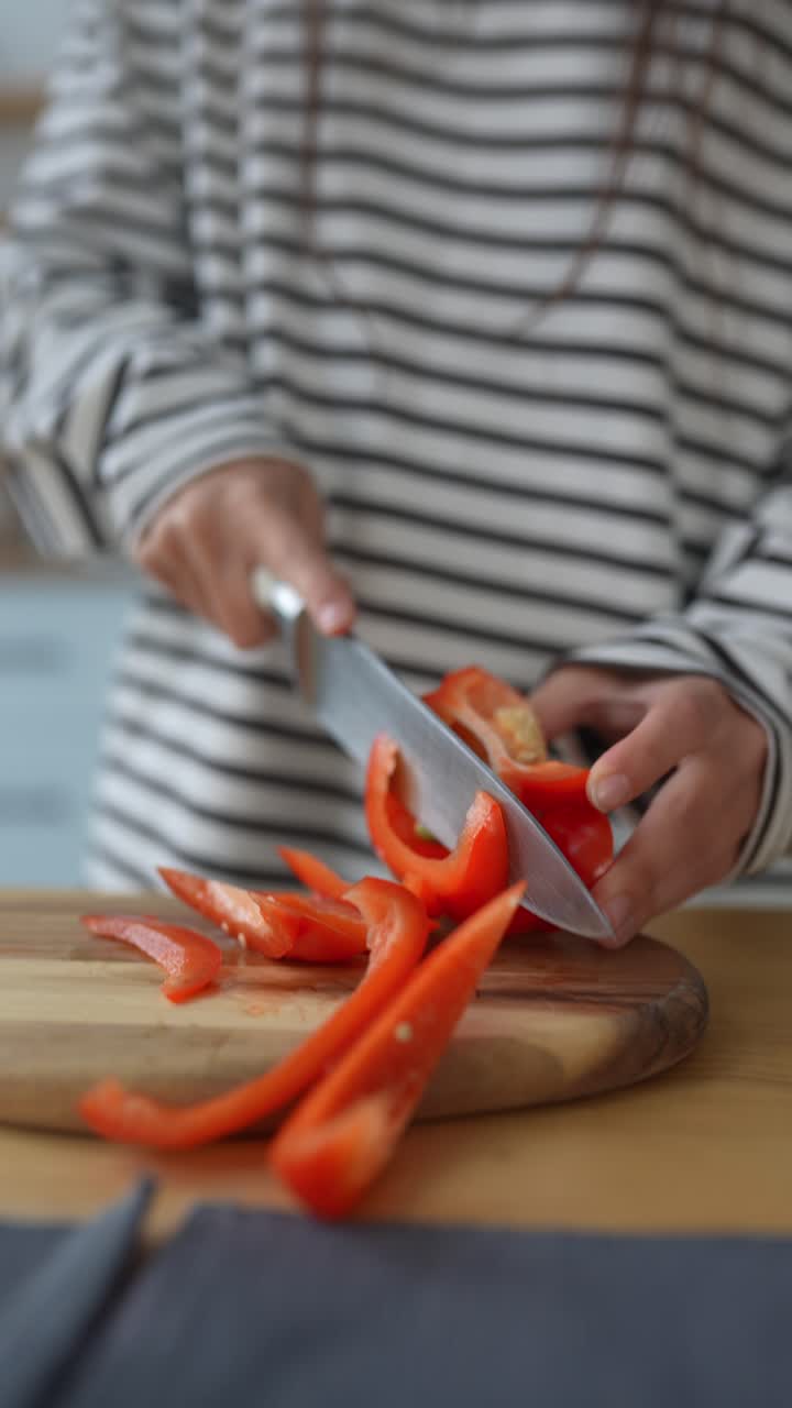 mujer cortando pimientos rojos