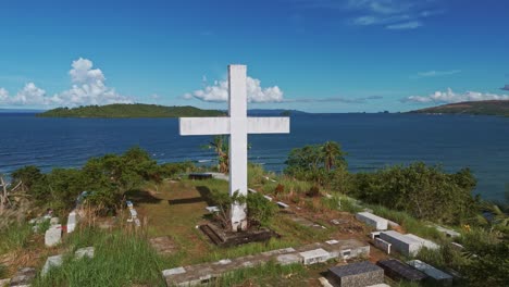 Aerial-point-of-interest-around-a-Cross-on-a-hilltop-and-cemetery,-Philippines