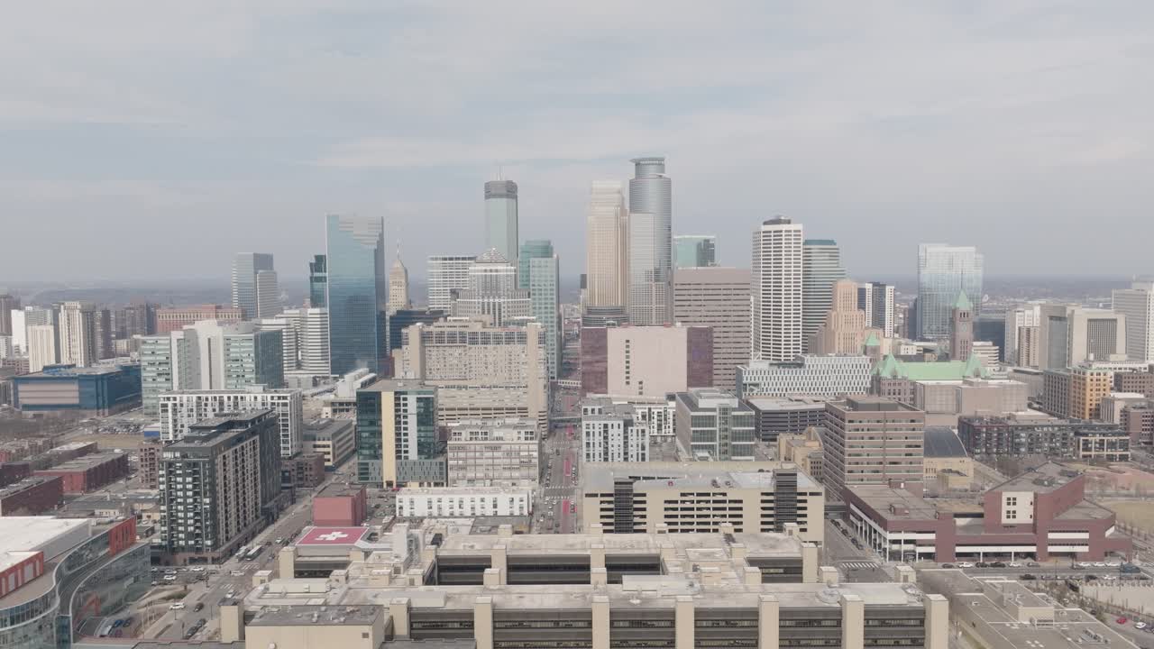 Aerial view of downtown Minneapolis skyline behind mid-rise buildings.