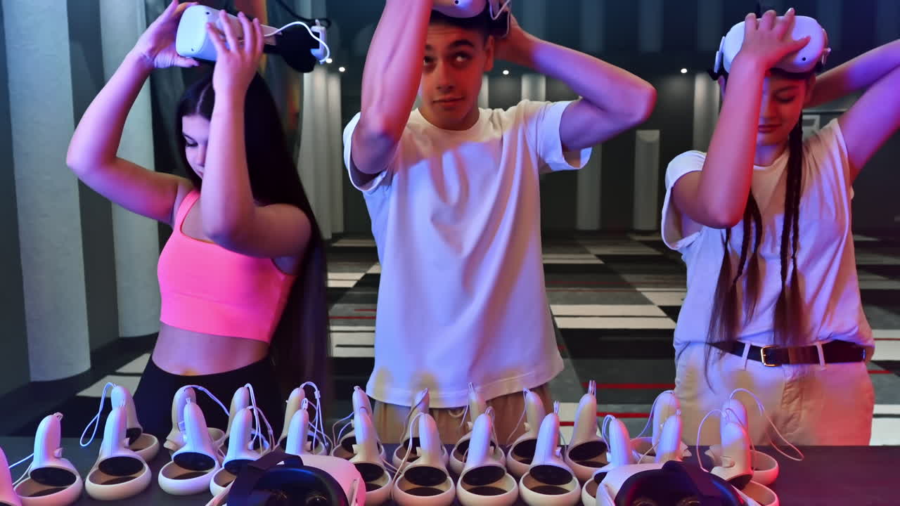 A team of young friends choosing and wearing VR virtual reality equipment on an arena