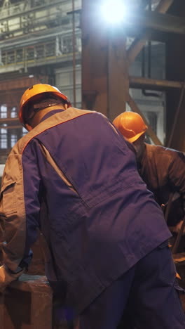 factory workers inspecting metal casting