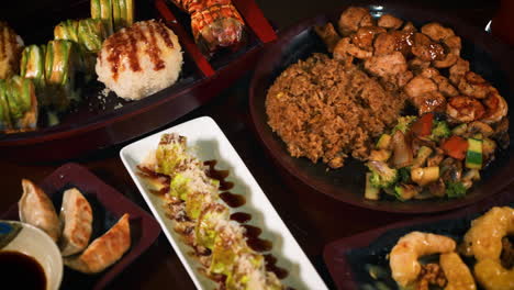mesa de restaurante japonés hibachi llena de variedad de opciones de menú, desde fideos hasta sushi, hibachi, tempura y gyoza, control deslizante 4k