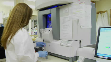 un técnico médico coloca viales de muestras en una gradilla 1