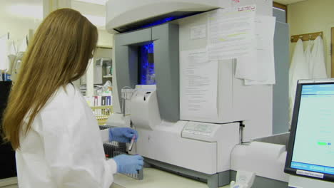 a medical technician places specimen vials into a rack 1