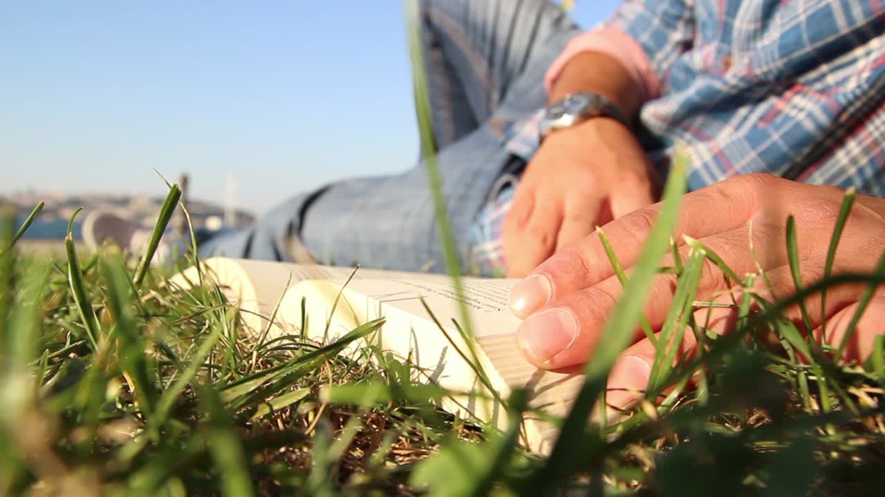 공원에서 책을 읽는 젊은 남자