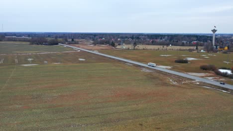 lorry and car driving on the road through fields in pasvalys, lithuania