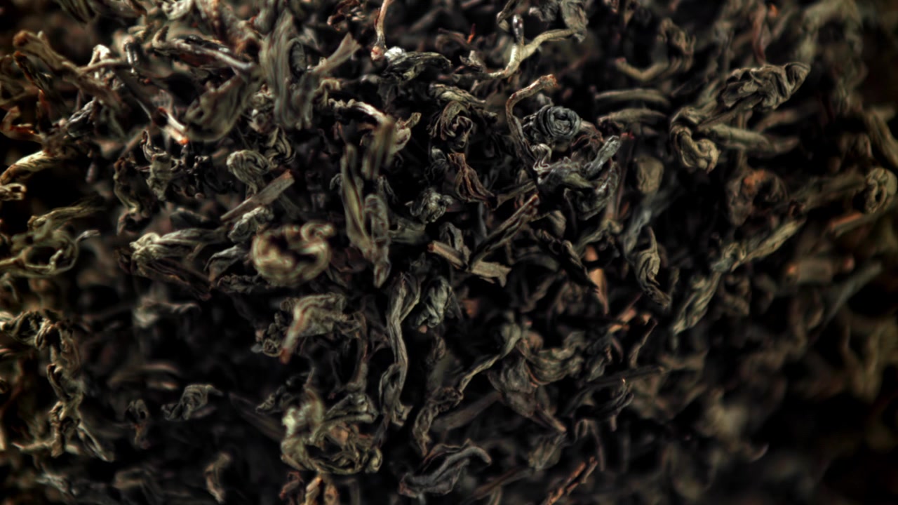 Close-up of Dry Tea Leaves Falling in Slow Motion