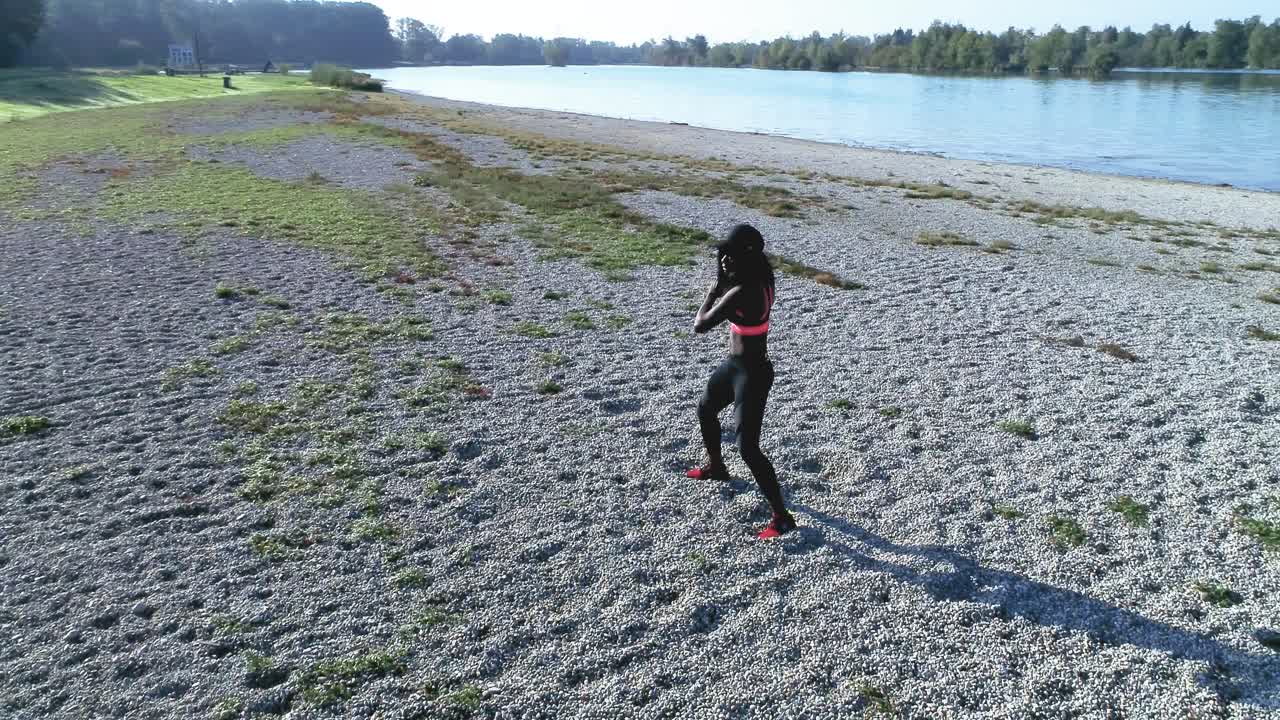 disparo de drones de una joven y atractiva mujer negra haciendo deportes al aire libre