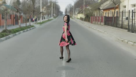 Una-Joven-Atractiva-Con-Un-Vestido-Con-Flores-Caminando-Por-La-Carretera.