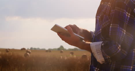 Farmer-Using-Digital-Tablet-At-Farm-Against-Blue-Sky-And-Clouds-2