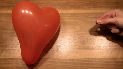 symbol of broken heart no love, by puncture a balloon in slow motion