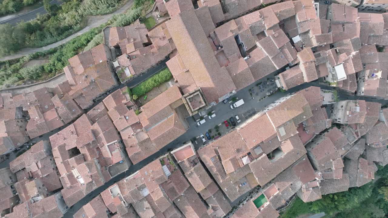 Top Down Aerial Drone view of the hilltop Medieval town of Pitigliano, Tuscany in morning light, with red tile roofs and old buildings, in 4K