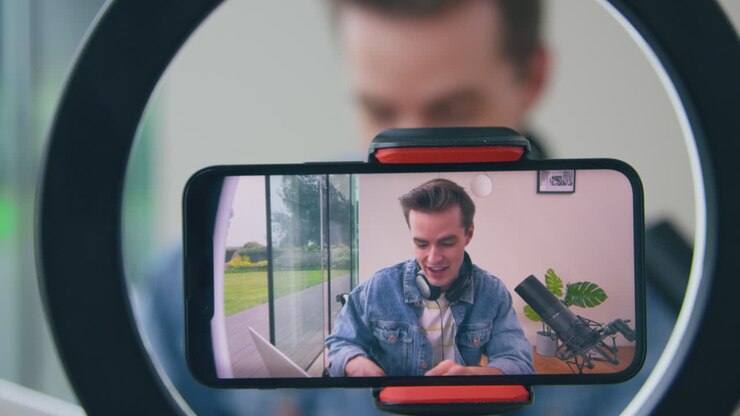 Vlogger uomo con cuffie e microfono in diretta streaming dal telefono cellulare.