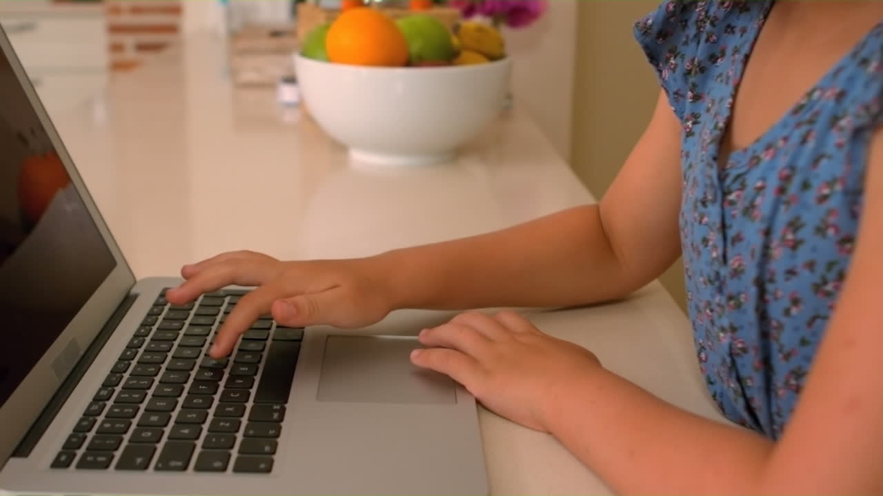 chica linda usando una computadora portátil en la cocina