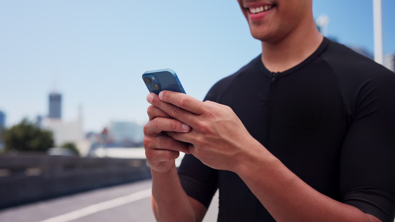 Uomo sorridente che usa lo smartphone all'aperto in città