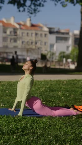 young woman practicing yoga in a park