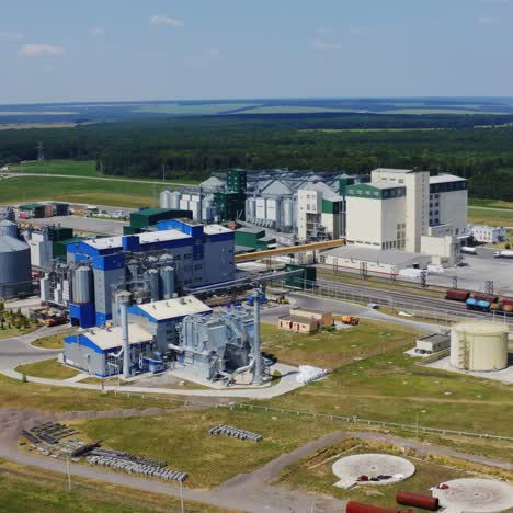 industrial plant among summer nature. modern territory for agribusiness on field. large steel silos for storing grains. aerial view.