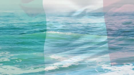 Digital composition of waving italy flag against waves in the sea