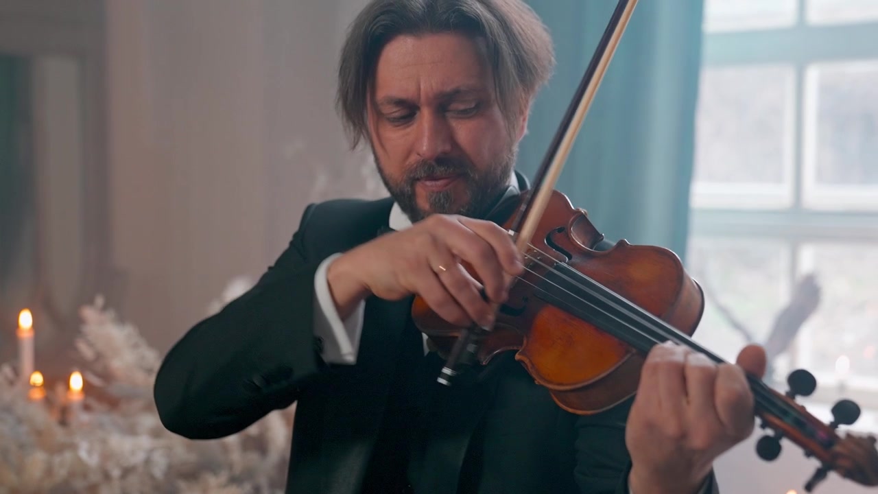 Musicista professionista che suona il violino in un'ambientazione formale.