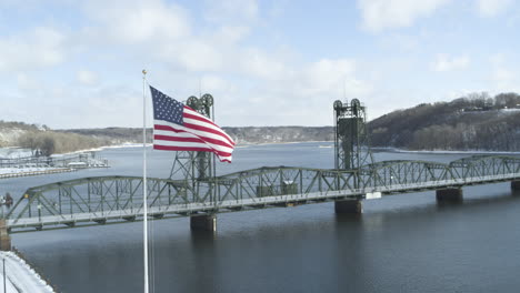 aerial orbit around waving usa flag and historic lift bridge in stillwater