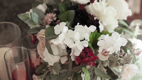 hermoso ramo de flores rojas y blancas y velas colocadas en una mesa como decoración para una cena de bodas