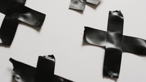 video de primer plano de la cinta negra formando cruces sobre un fondo blanco